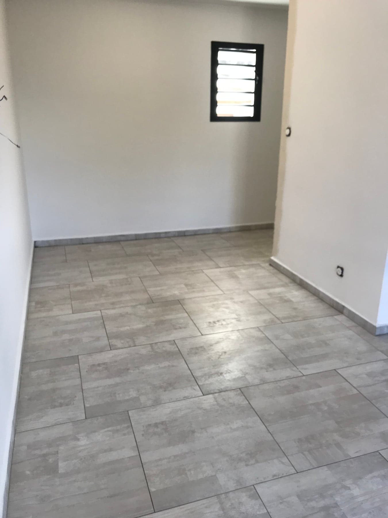 Chambre carrelée en grand format gris aspect béton