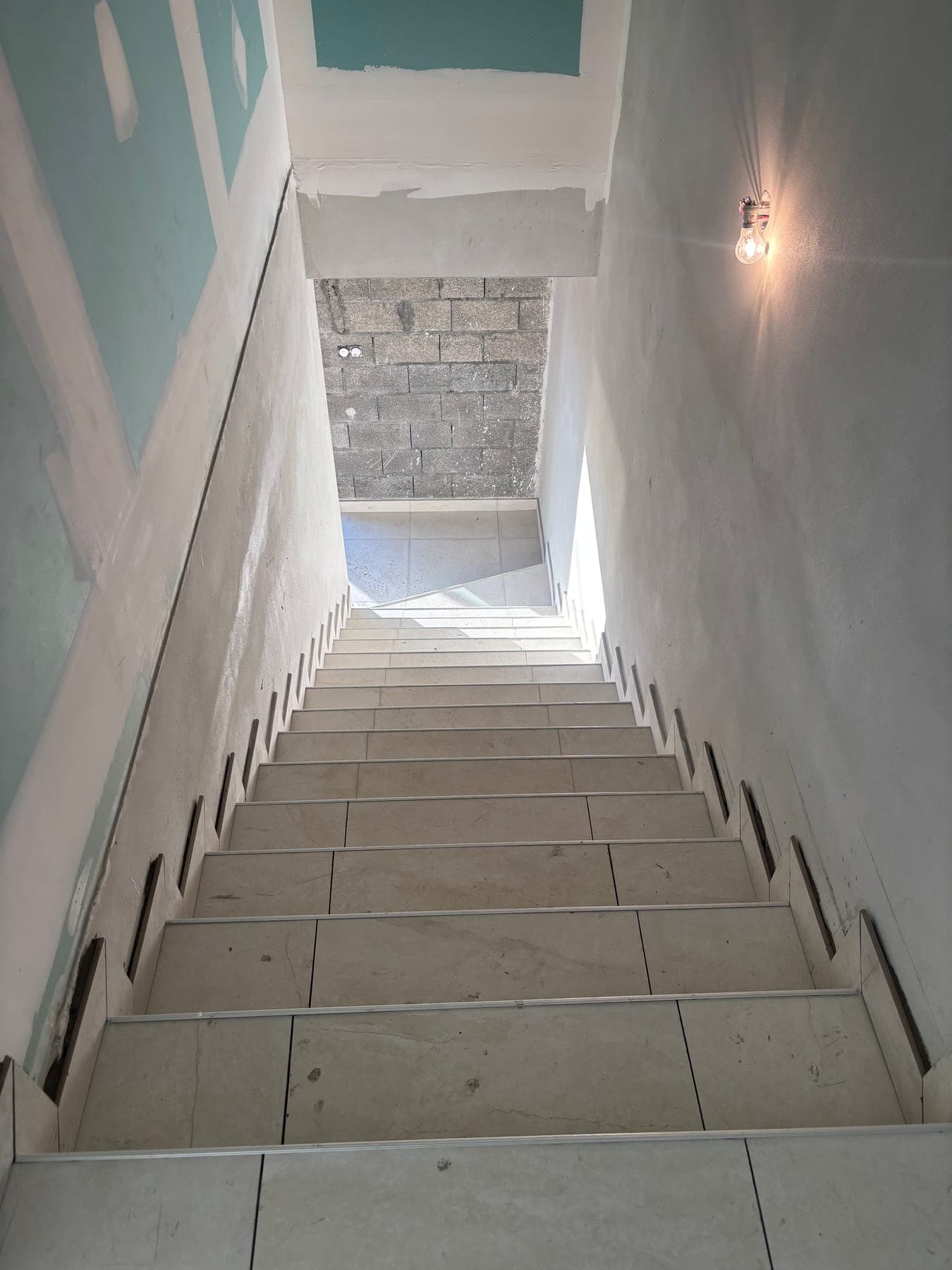 Vue plongeante sur un escalier carrelé depuis le haut de la cage d'escalier