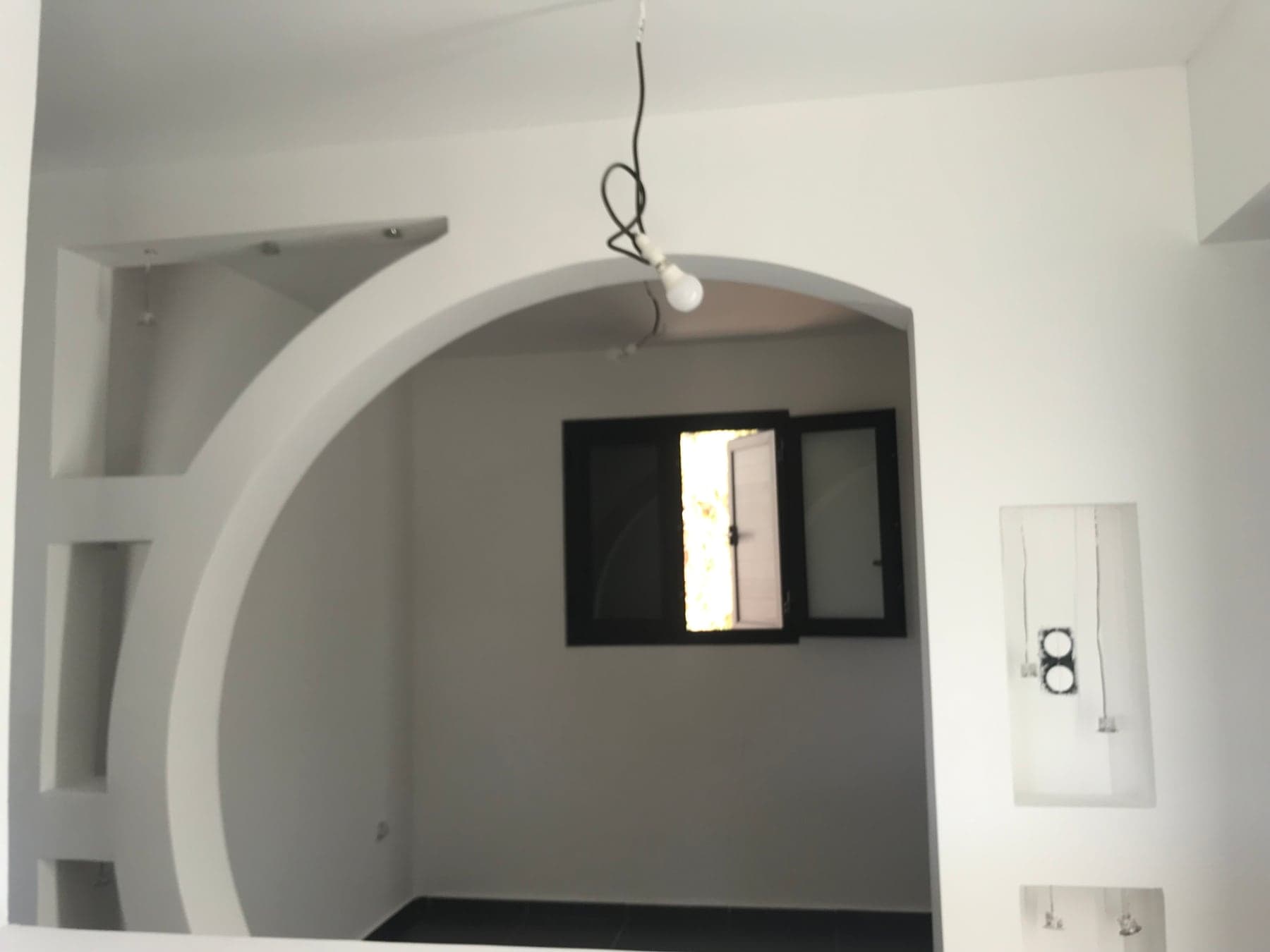 Niches maçonnées sous l'arche et carrelage noir grand format posé