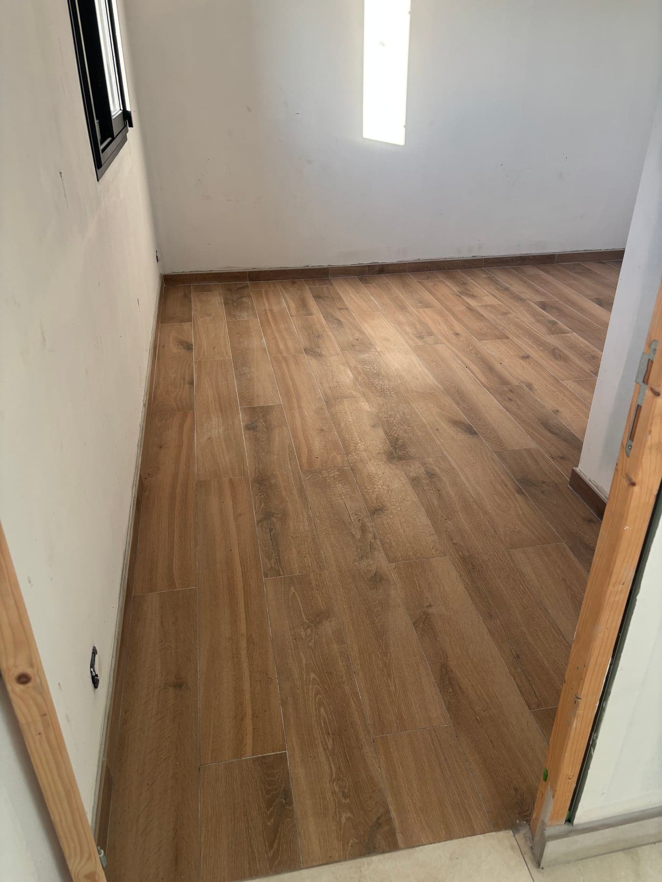 Palier de l'étage carrelé en imitation bois jusqu'au garde-corps