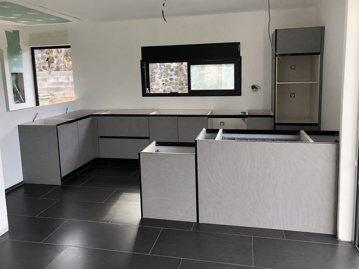 Caissons de la cuisine posés en L et alignés, avant pose du plan de travail