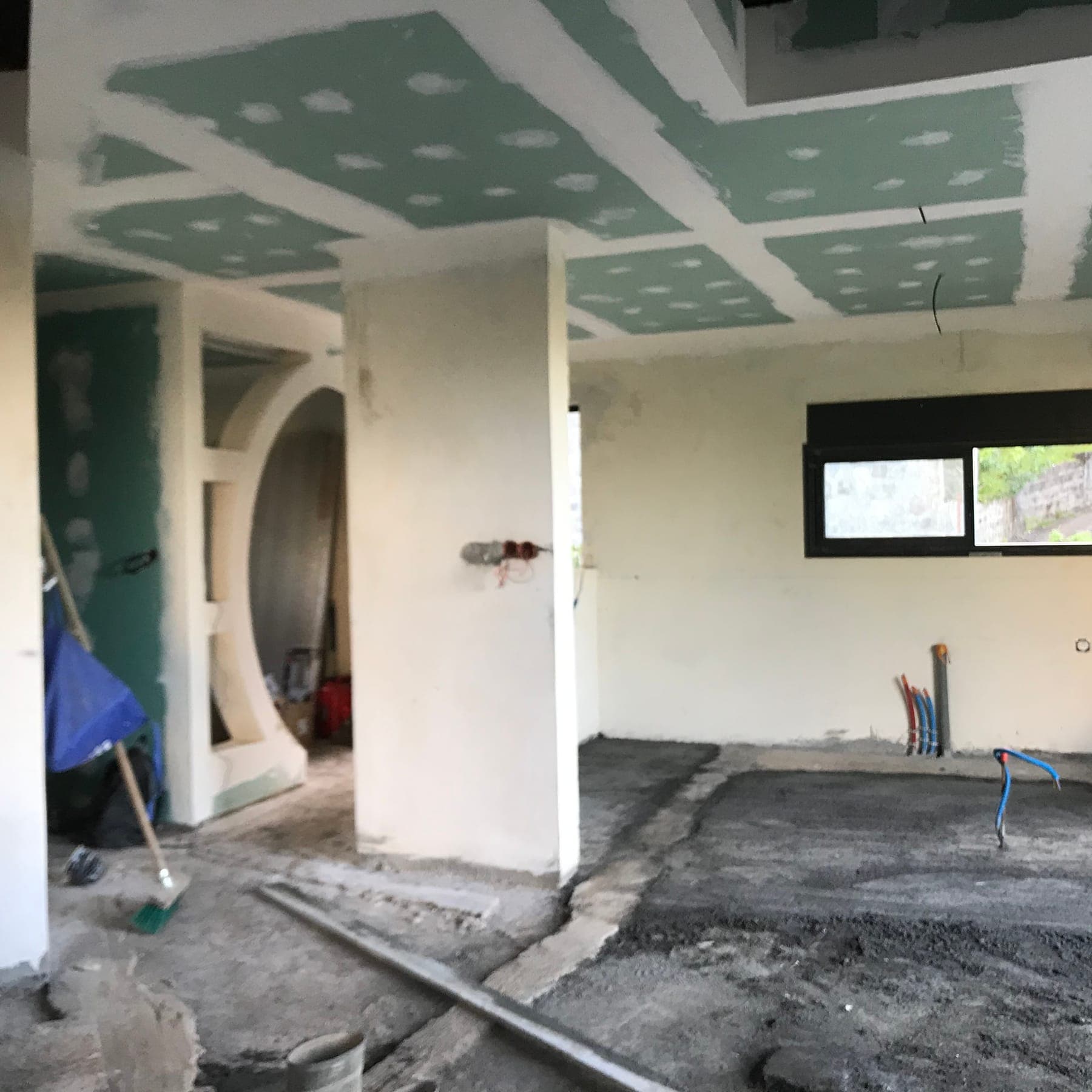Avant travaux : cloisons en plaques de plâtre et sol brut avant l'aménagement