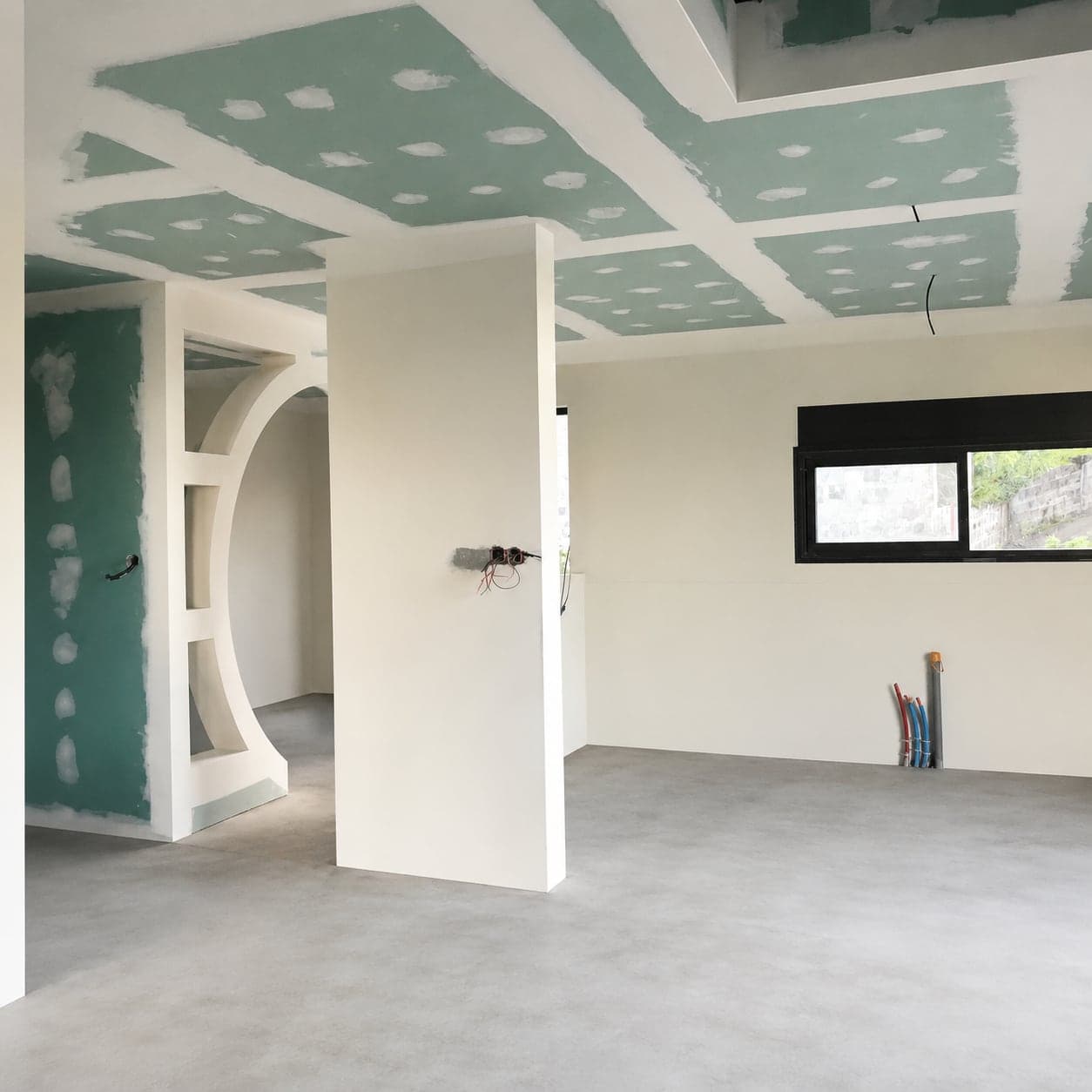 La pièce avant travaux : cloisons montées, plafond en plaques et arche maçonnée