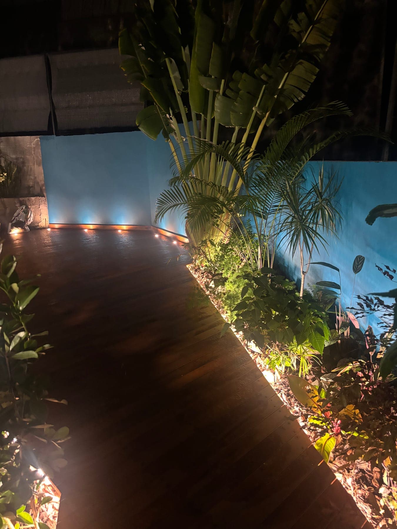 Terrasse en bois éclairée de nuit par des spots encastrés en périphérie